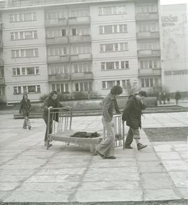 Mężczyźni niosący stare łóżko